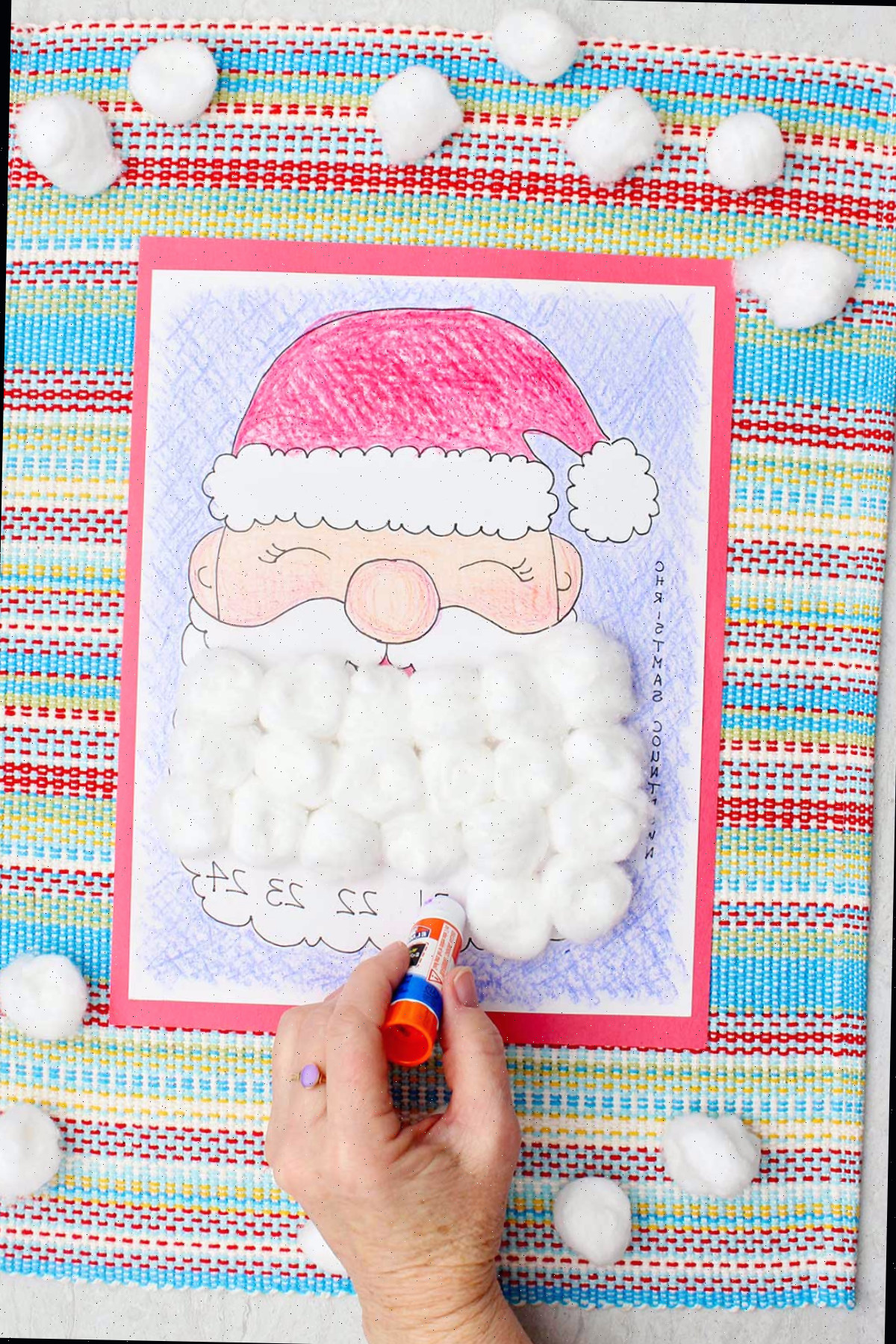 Alguém aplicando cola em um dia da barba do Papai Noel no calendário de contagem regressiva.
