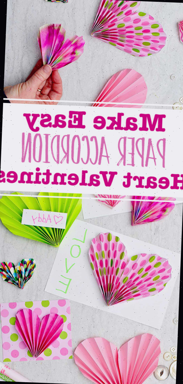 Acordeões de papel rosa e verde usados para ornamentar cartões e valentins, com algumas canetas e botões dispersos nas imediações e uma imagem de uma pessoa segurando um coração de papel em acordeão colorido.