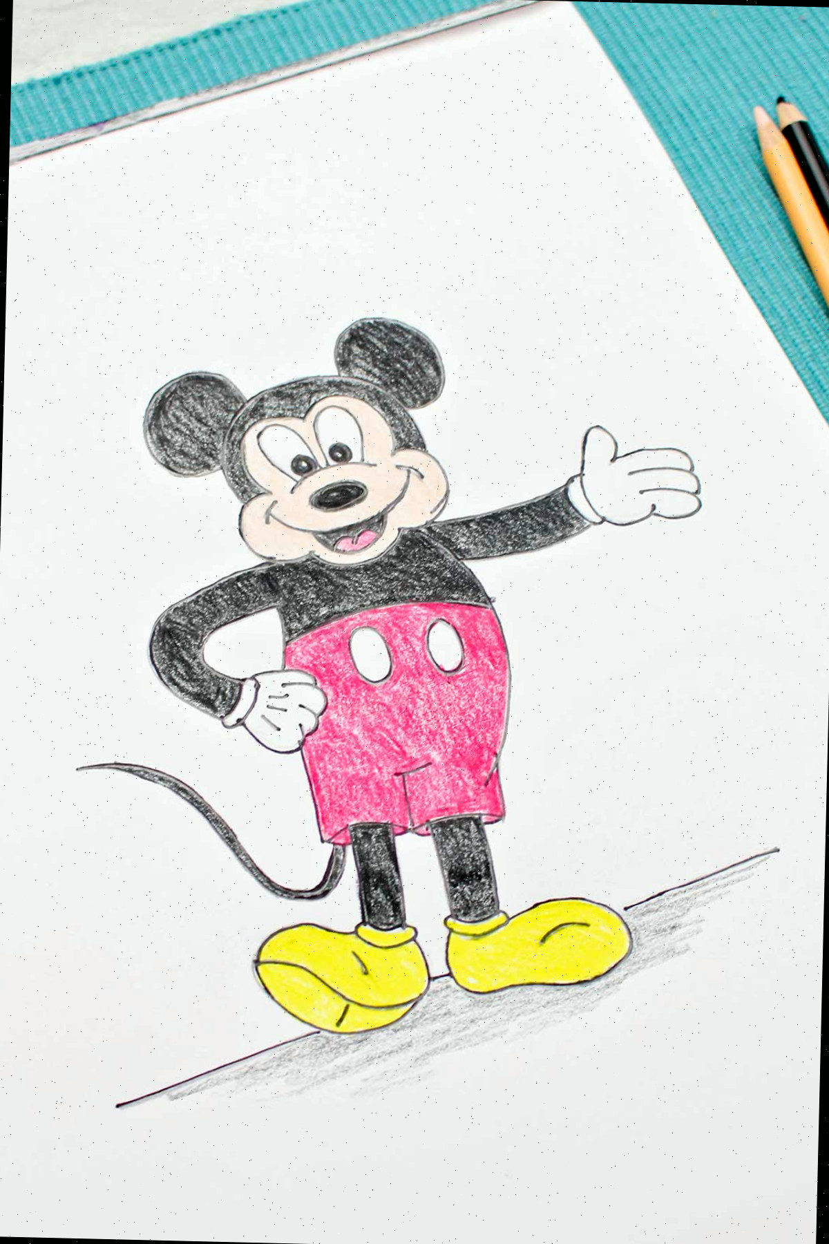 Um esboço colorido e completo do Mickey Mouse com a mão na cintura e o outro braço estendido.