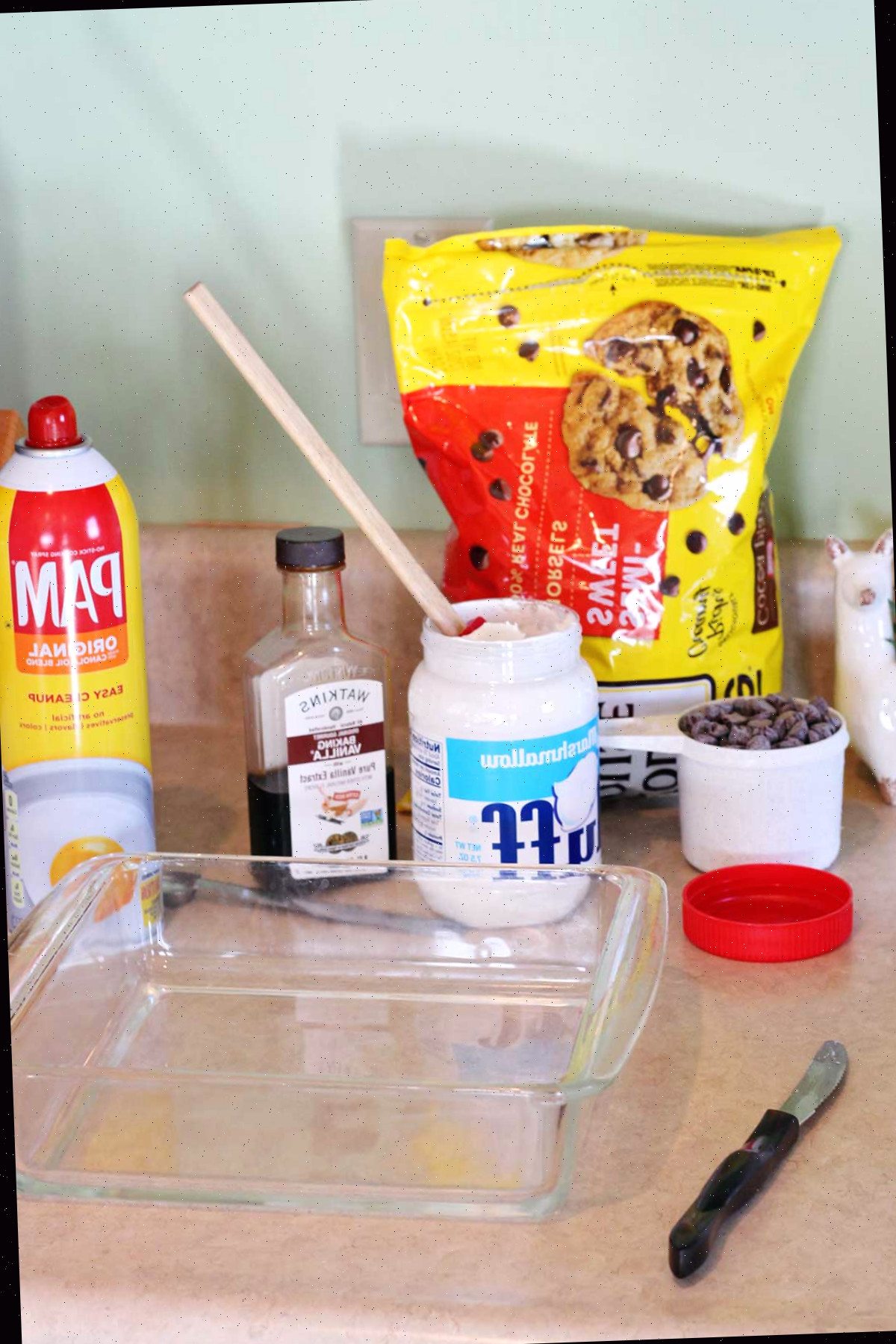 Ingredientes para o fudge e uma forma de vidro 8x8 em um balcão.