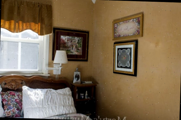 Um quarto com uma cama e uma pintura na parede