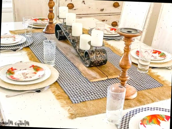 Uma mesa posta com pratos de comida sobre um prato, com caminho de mesa e toalha de mesa