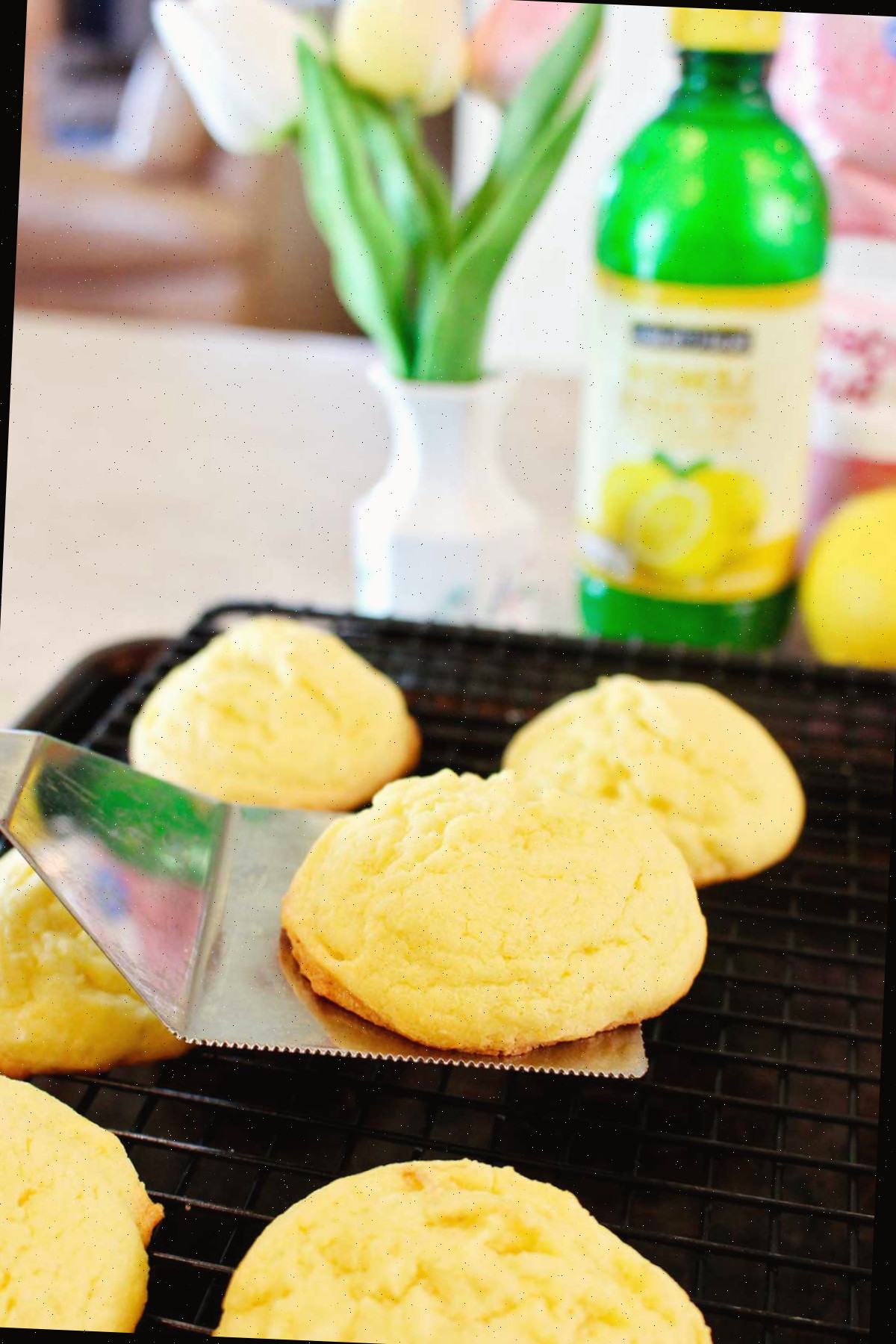 Uma pessoa levantando um biscoito recém-assado e colocando-o em uma grade para esfriar.