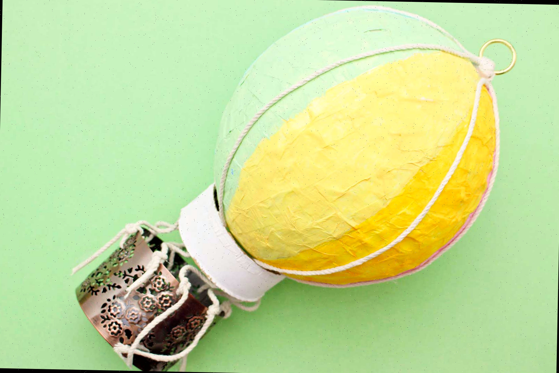 Um balão de ar quente de papel machê contra um fundo verde.