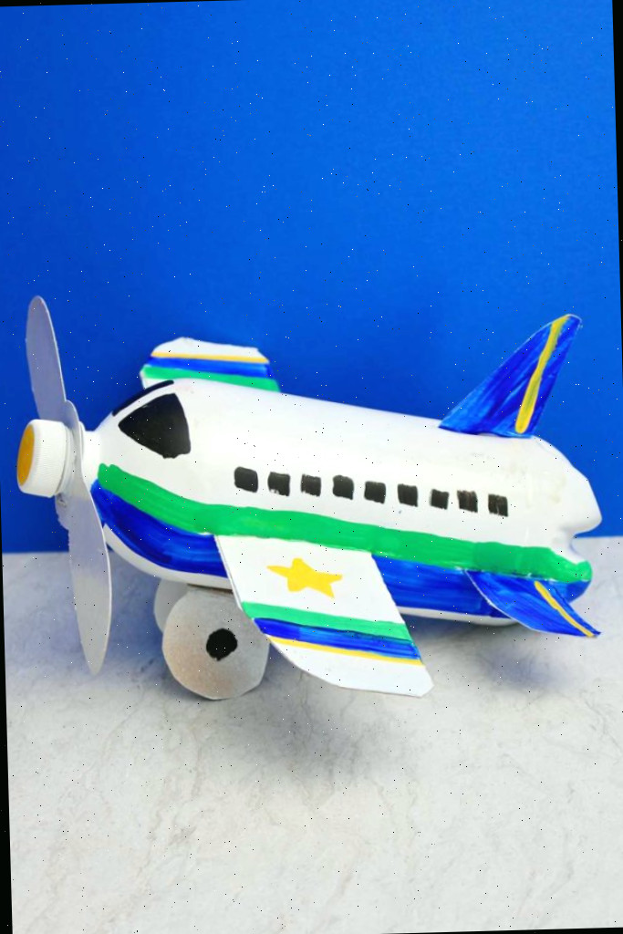 Artesanato em garrafa de avião completamente pintado e finalizado contra um fundo azul.