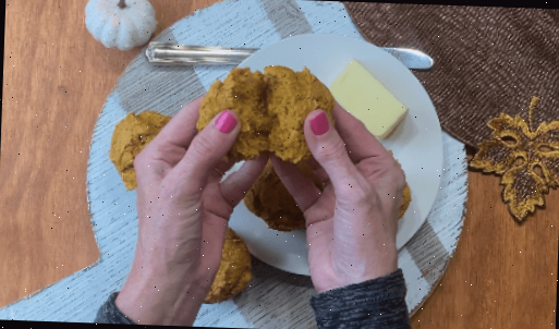 muffin de abóbora partido ao meio nas mãos de uma mulher