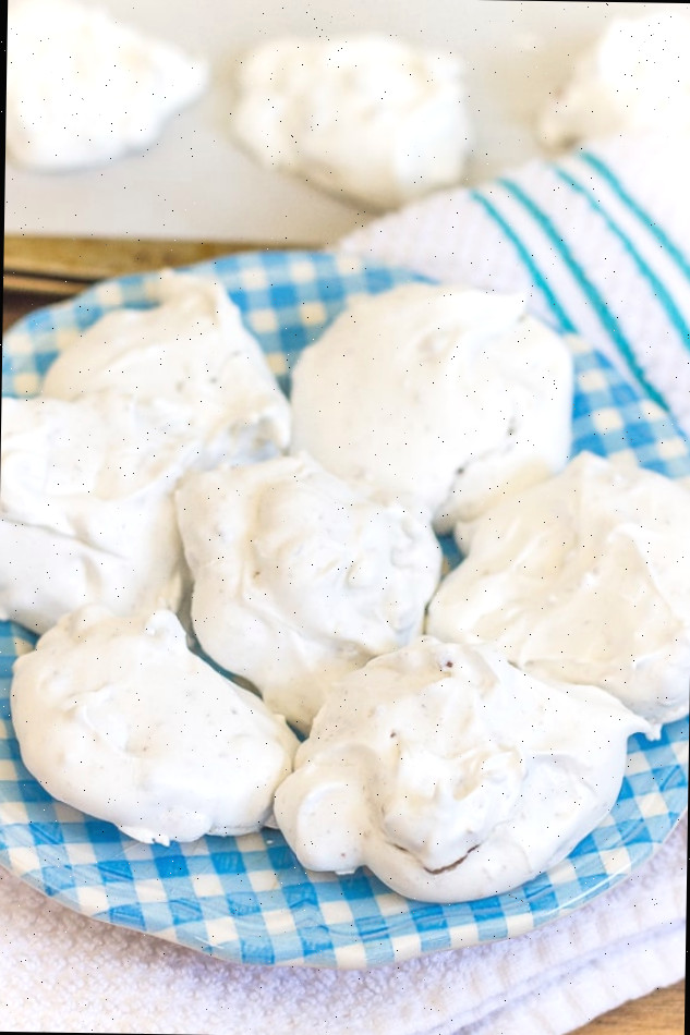 Biscoitos de merengue brancos em prato azul com biscoitos na assadeira