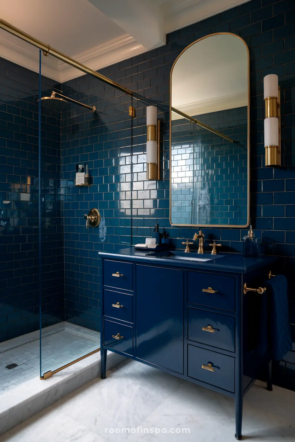 Um banheiro neutro com paredes bege e um backsplash de ladrilhos azul escuro atrás da vaidade, iluminado por uma luz suave.