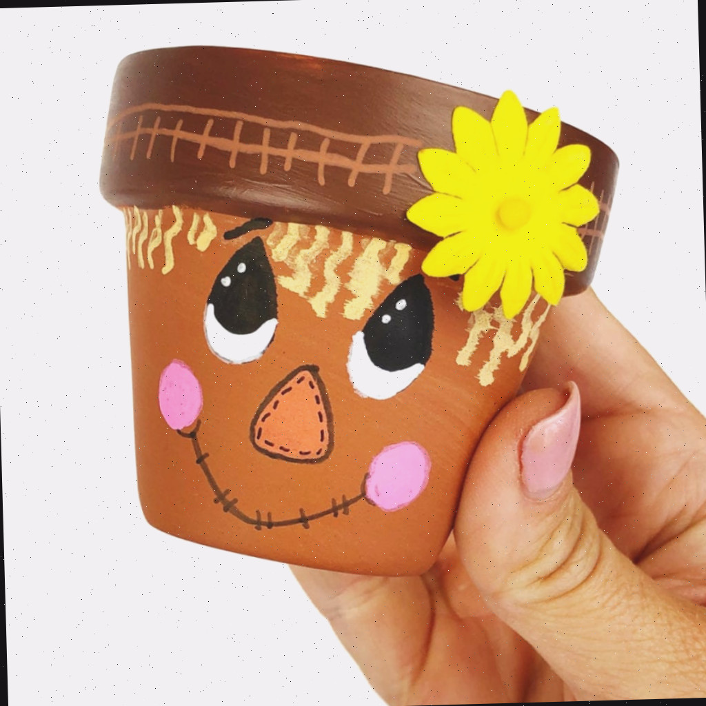 Close up do espantalho pintado em um mini vaso de flores