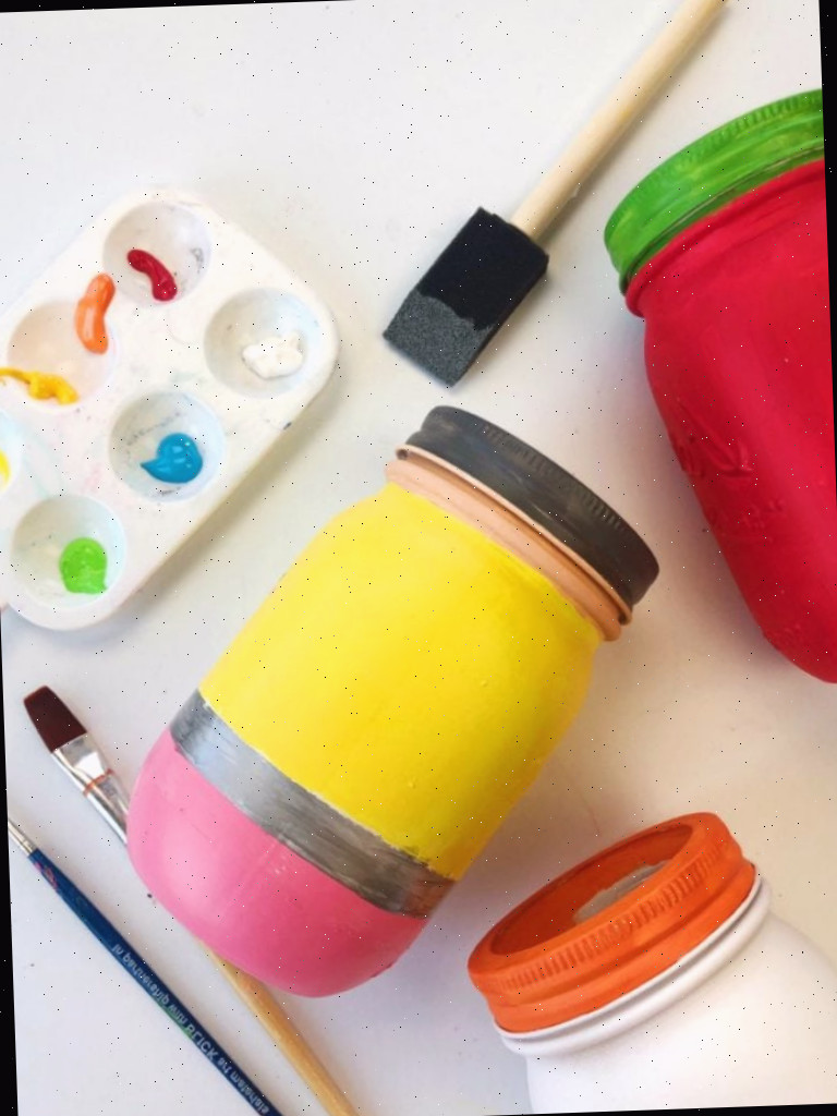 Jarras de conservas pintadas para parecerem materiais escolares - pincéis de diferentes tamanhos são mostrados