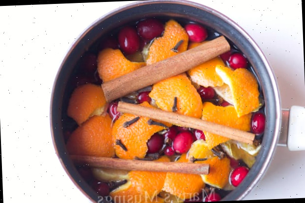 Pot-pourri em uma panela com laranjas, cranberries e paus de canela