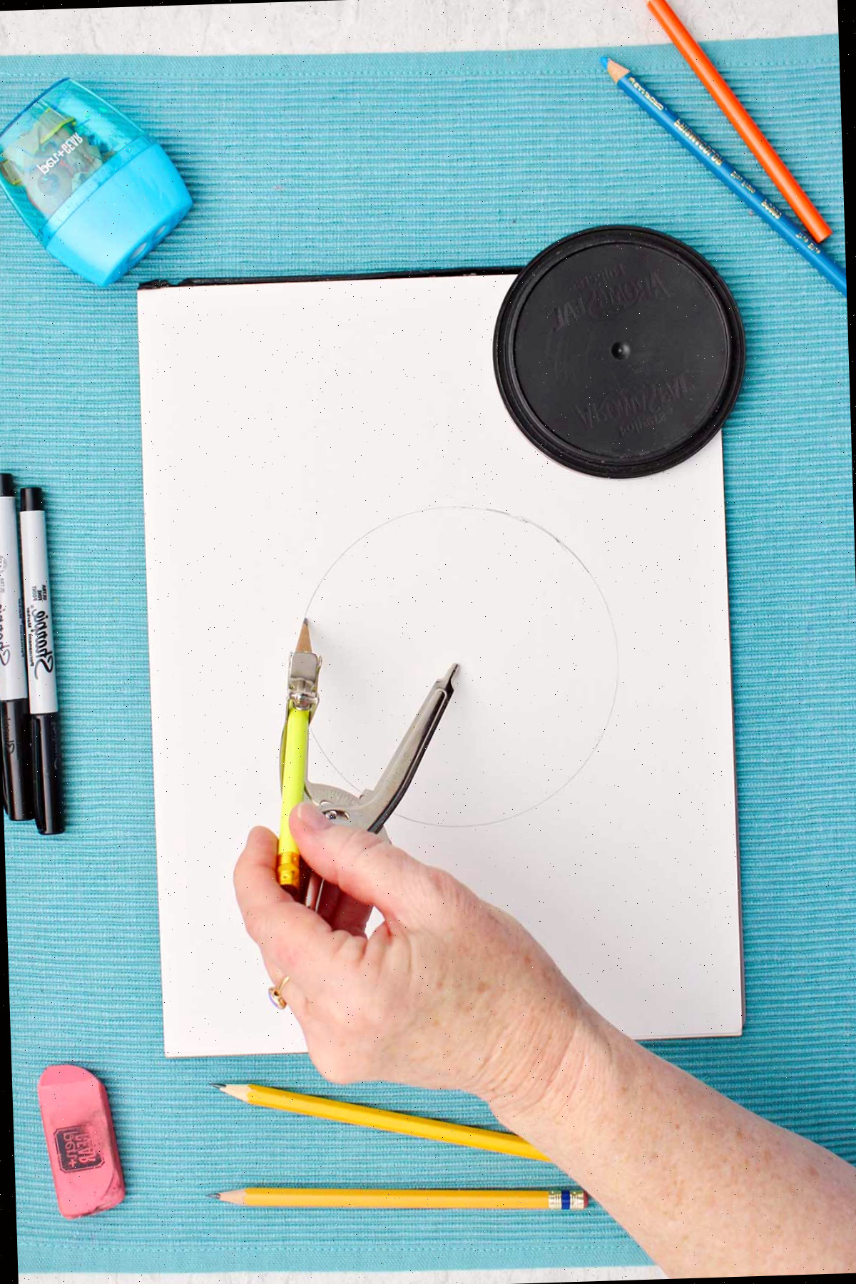 Pessoa utilizando um compasso para desenhar um círculo.