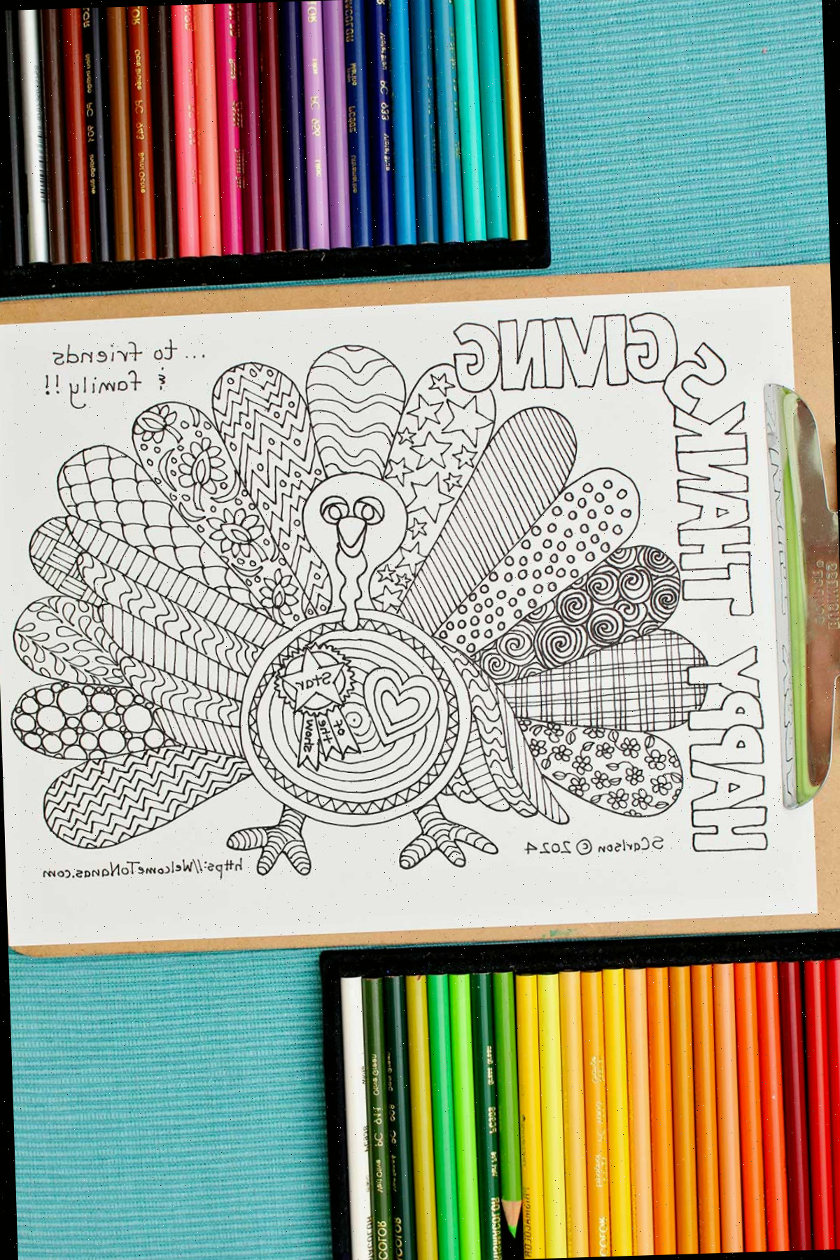 Página de colorir de Ação de Graças não colorida presa a uma prancheta com duas partes de lápis de cor próximos.
