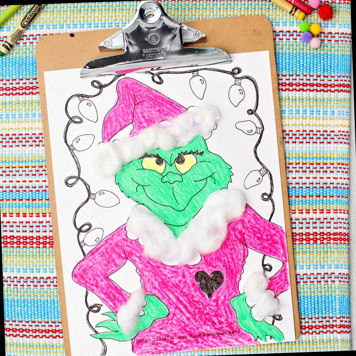 Página para colorir do Grinch completa com acentos de bolinhas de algodão fixados em uma prancheta.