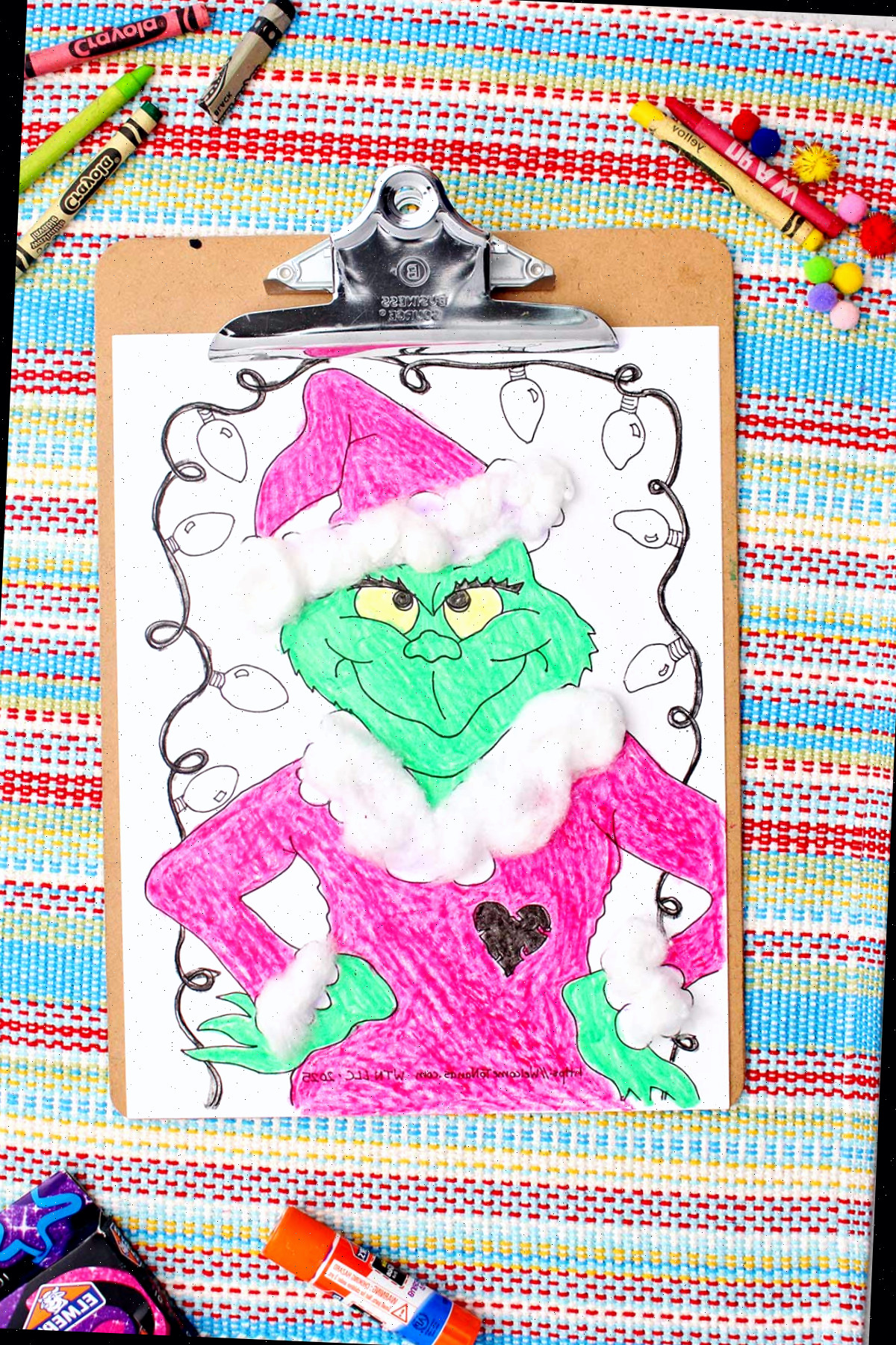 Grinch colorido impresso completo com detalhes de bolinha de algodão presos em uma prancheta.