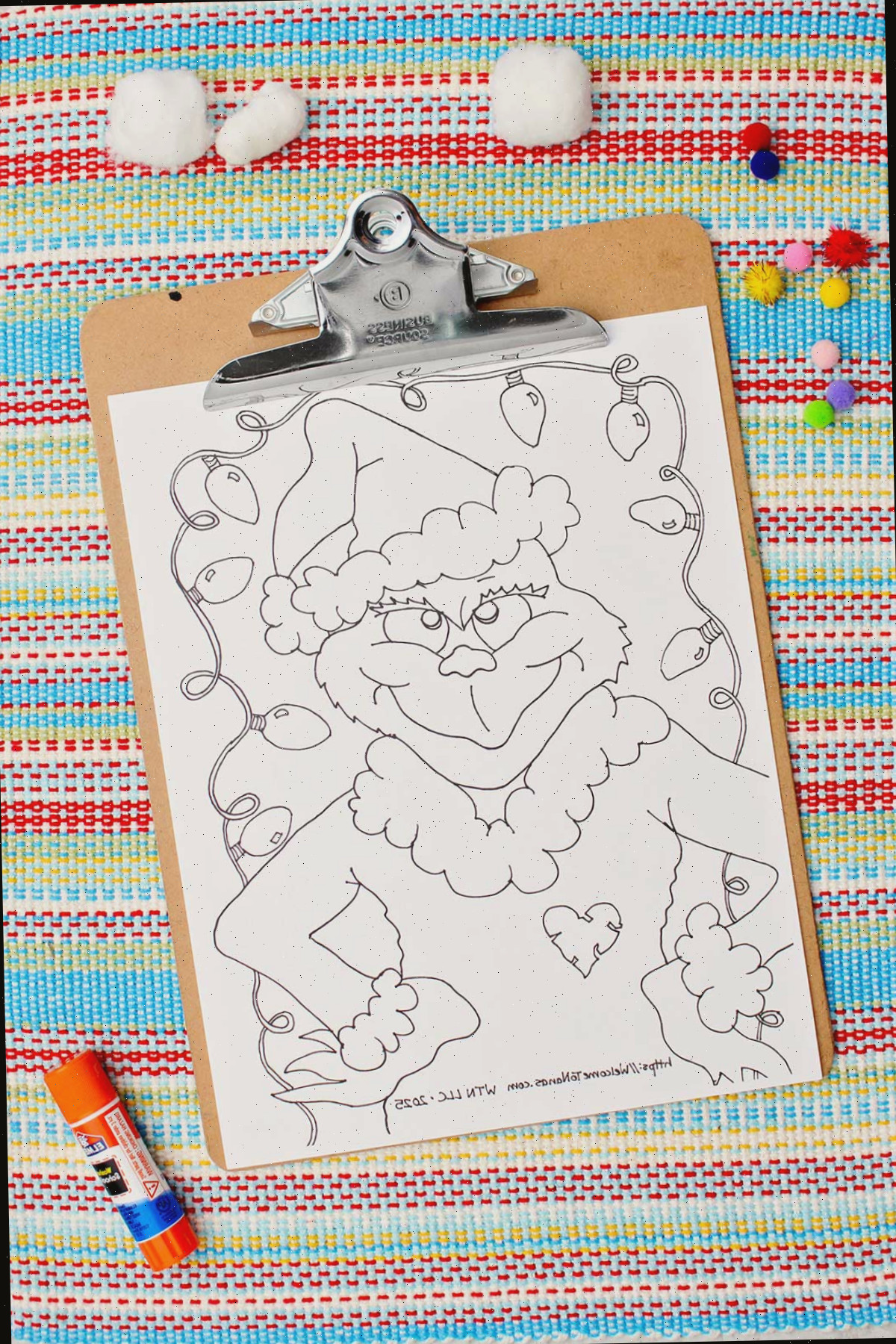 Página de colorir do Grinch não colorida em uma prancheta.
