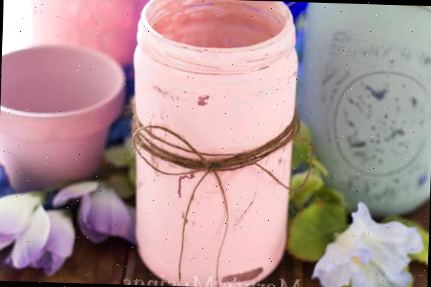 Uma xícara de café sobre uma mesa, com um pote mason jar