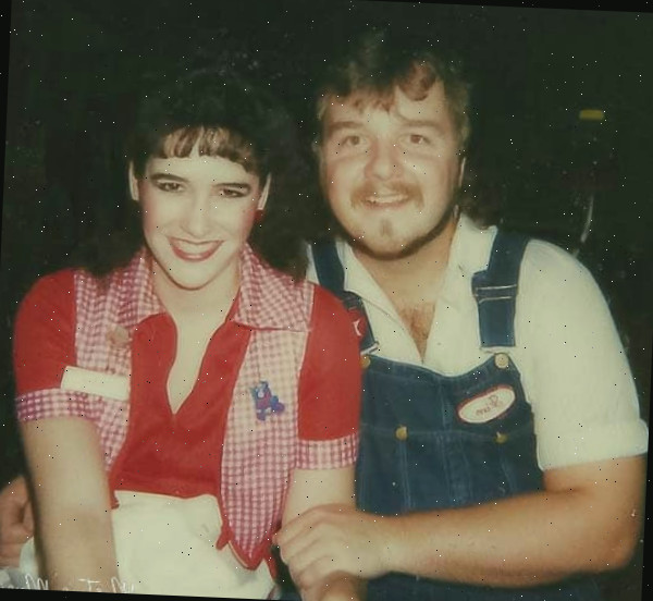 Um homem e uma mulher posando para uma foto, com saco de presente