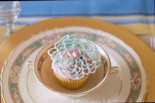 Uma mesa com um bolo sobre um prato, com cupcake