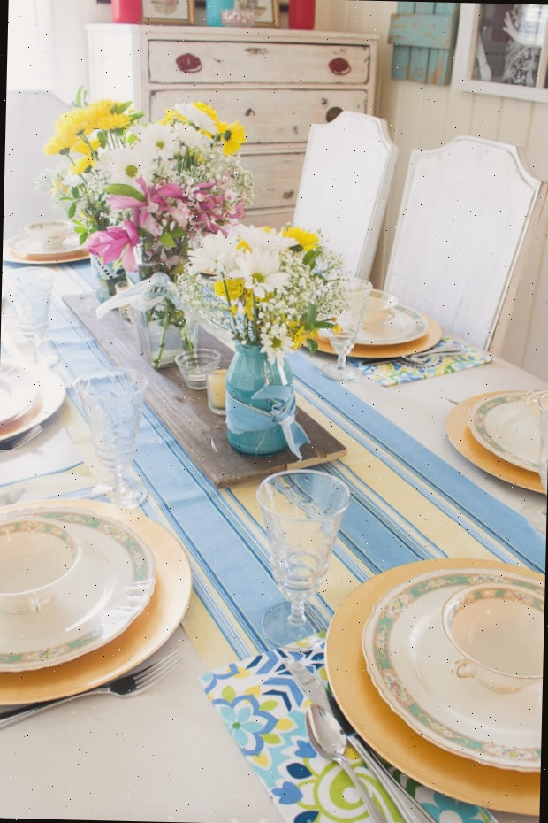 Um prato com um vaso de flores sobre uma mesa, com azul e amarelo