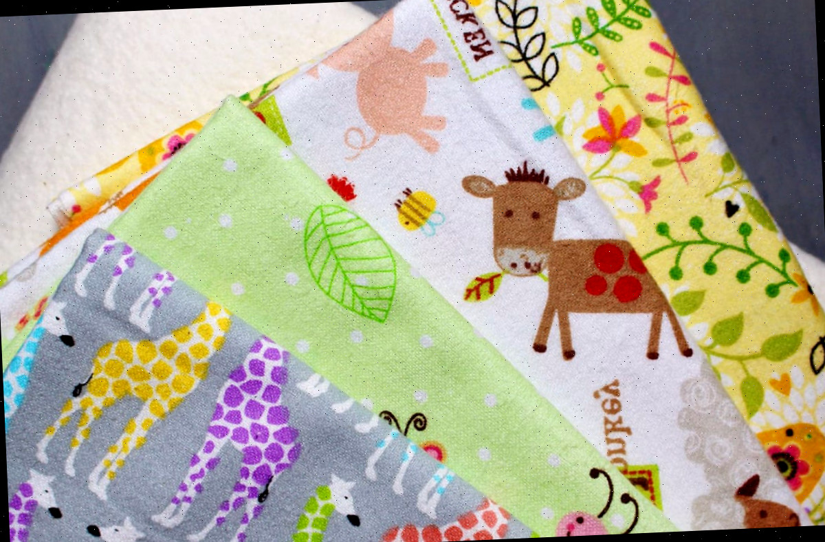 Uma pilha de estampas de tecido de feltro colorido prontas para serem confeccionadas em toalhas de arroto de bebê.