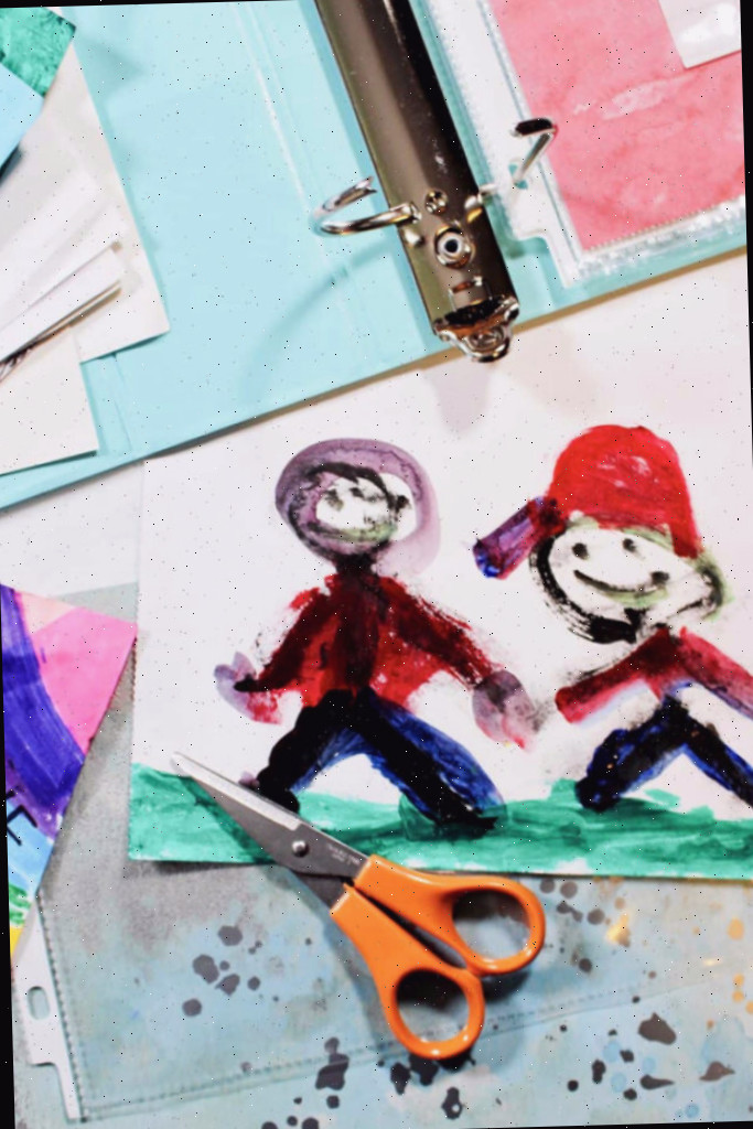 Pintura de uma criança de duas pessoas de mãos dadas, com tesouras, um fichário e papel de scrapbook nas proximidades.