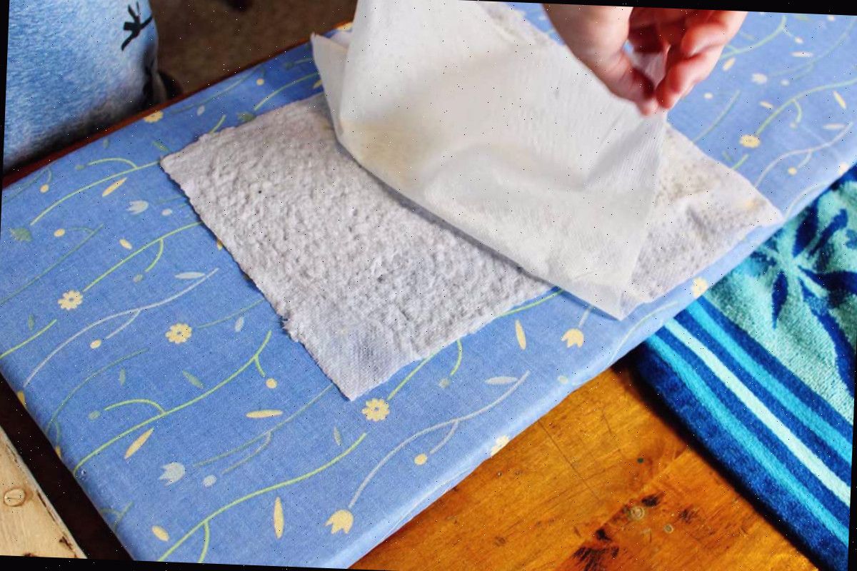 Retirando uma toalha de papel de uma página de polpa de papel reciclado.