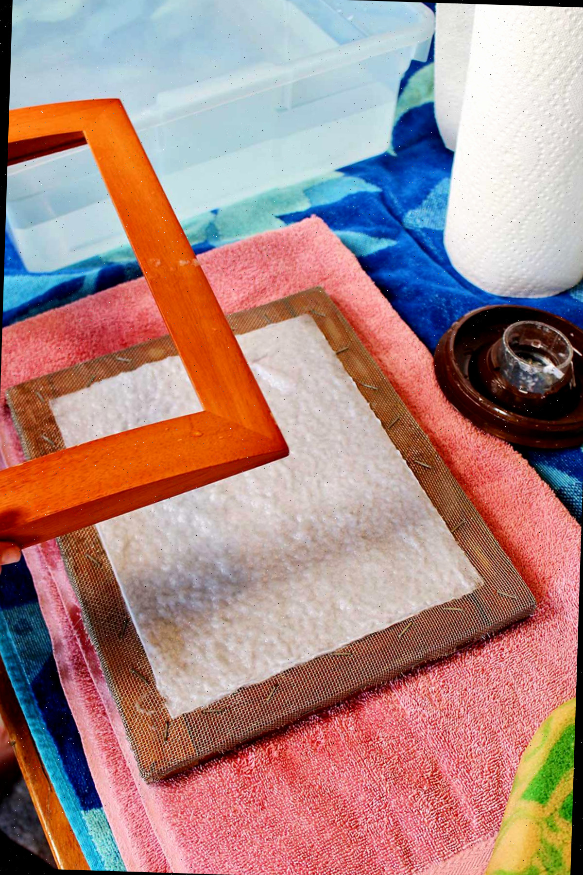 removendo o molde de um molde e deckle com papel reciclado recém-feito.
