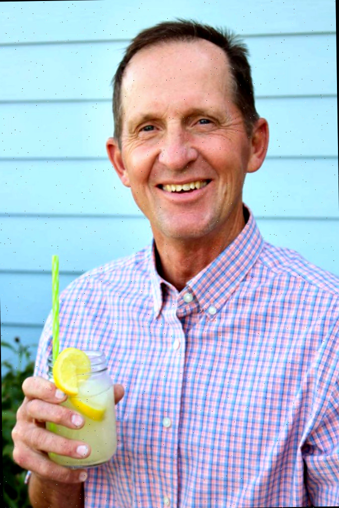 Um homem segurando um copo de limonada ao ar livre