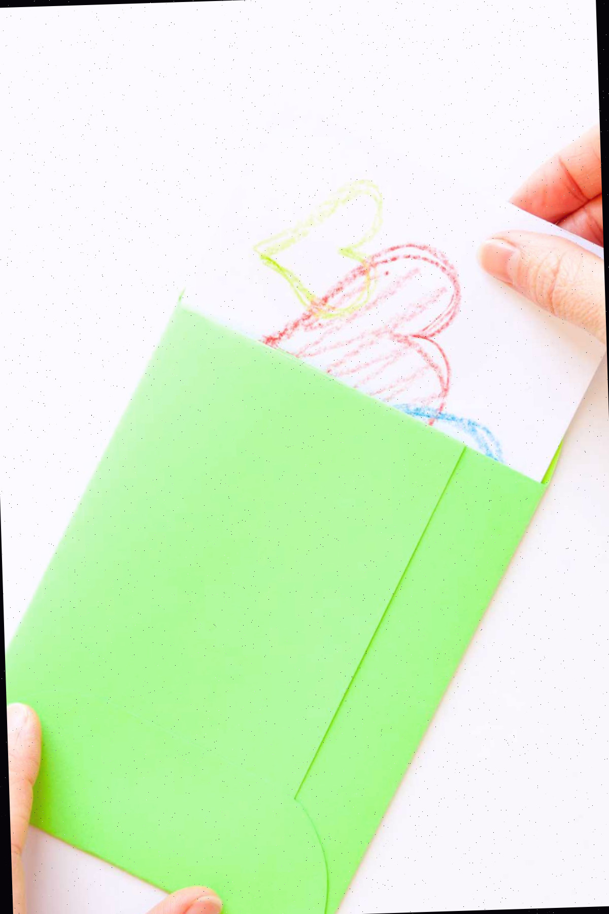 Puxando um cartão com corações de um envelope verde.
