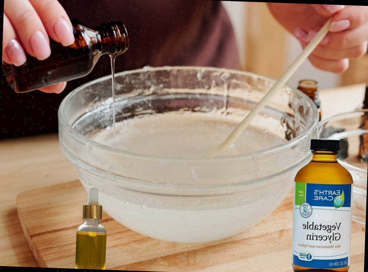 Adicionando glicerina, vitamina E e óleo essencial. Mulher adicionando óleo essencial a uma tigela com sabão líquido caseiro. Frascos de glicerina e vitamina E ficam ao lado da tigela.