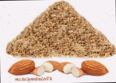 Farinha de amêndoas em uma pilha acima de uma fileira de amêndoas cruas.