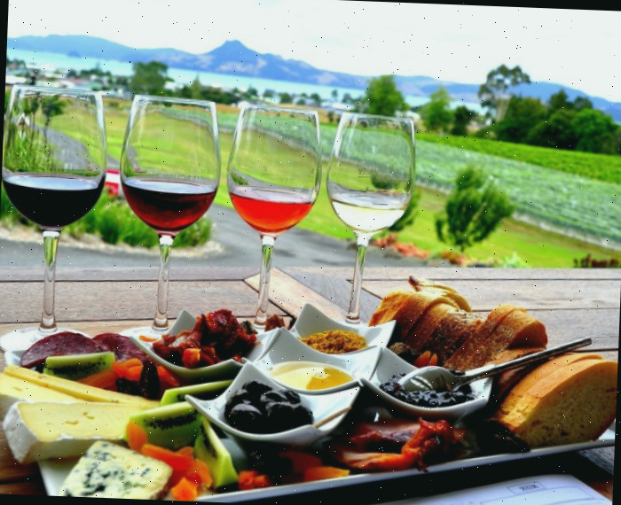Prato de antipasto e taças de vinho em um ambiente externo.