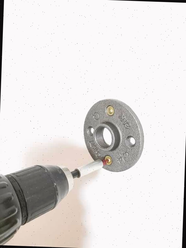 Fixando a flange na parede com chave de fenda para a moldura flutuante