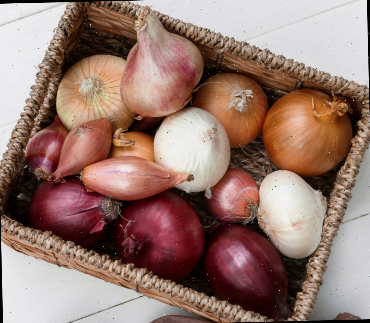 Uma cesta repleta de chalotas e outros alliums.