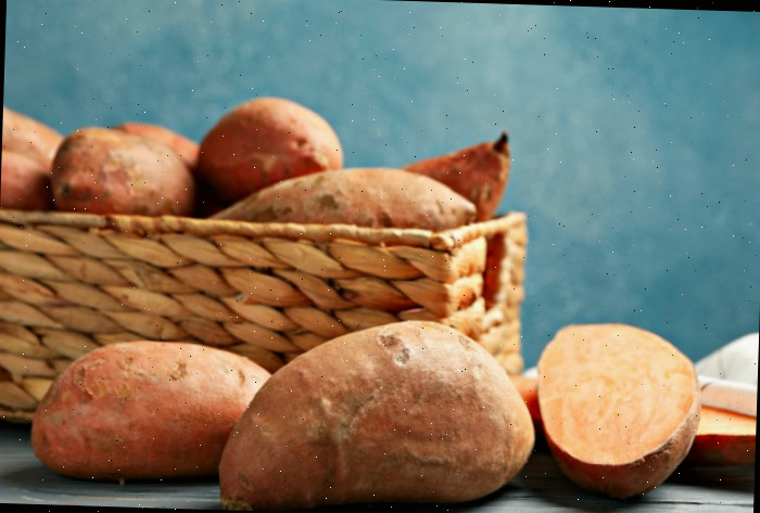 Uma cesta com batatas-doces orgânicas saudáveis e uma batata-doce cortada.
