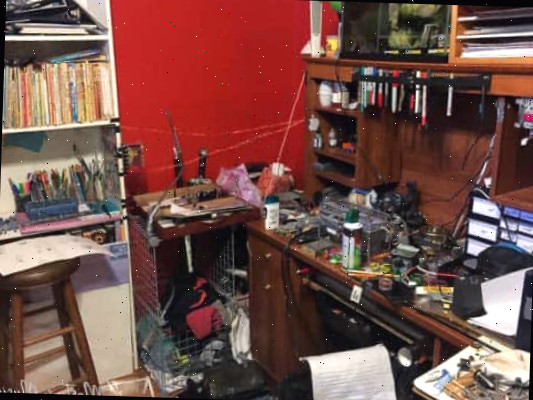 Uma escrivaninha cheia de itens com uma estante de livros