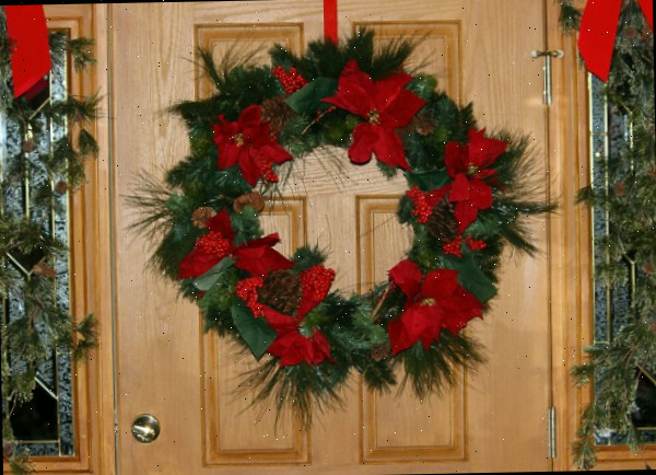 Guirlanda de Natal Tradicional com laços vermelhos na porta da frente.