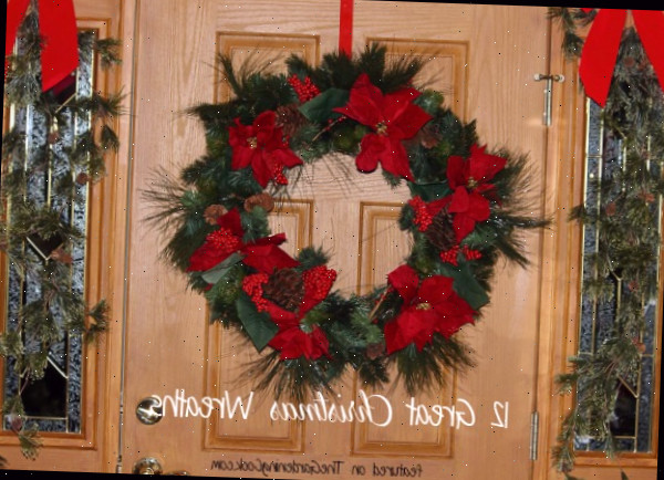 Guirlanda com laços vermelhos em uma porta e palavras 12 ótimas guirlandas de Natal.