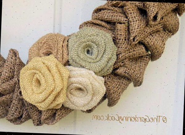 Um conjunto de quatro rosas de juta em uma guirlanda de boas-vindas de juta.