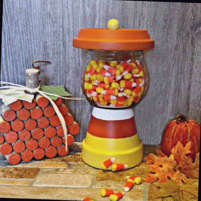 Um prato de doces DIY em uma vignette de outono com folhas caídas, uma abóbora falsa e o artesanato de abóbora de rolha de vinho.