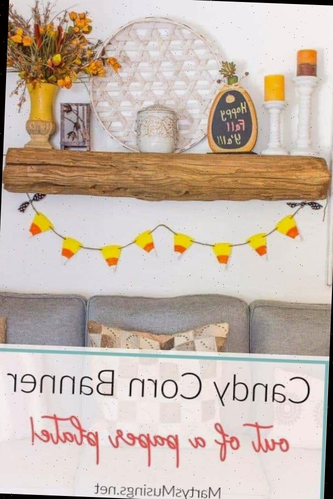 banner de candy corn pendurado em uma lareira de madeira de celeiro