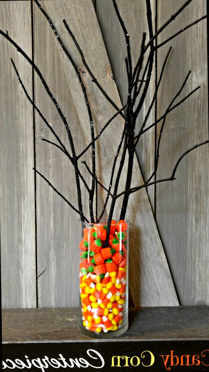 centro de mesa de Halloween com doce de milho Doce de milho e galhos de árvores escuros criam um ótimo centro de mesa para o Halloween