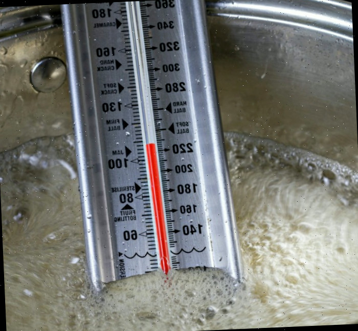 Usando um termômetro de confeitaria termômetro de confeitaria em uma panela de açúcar.