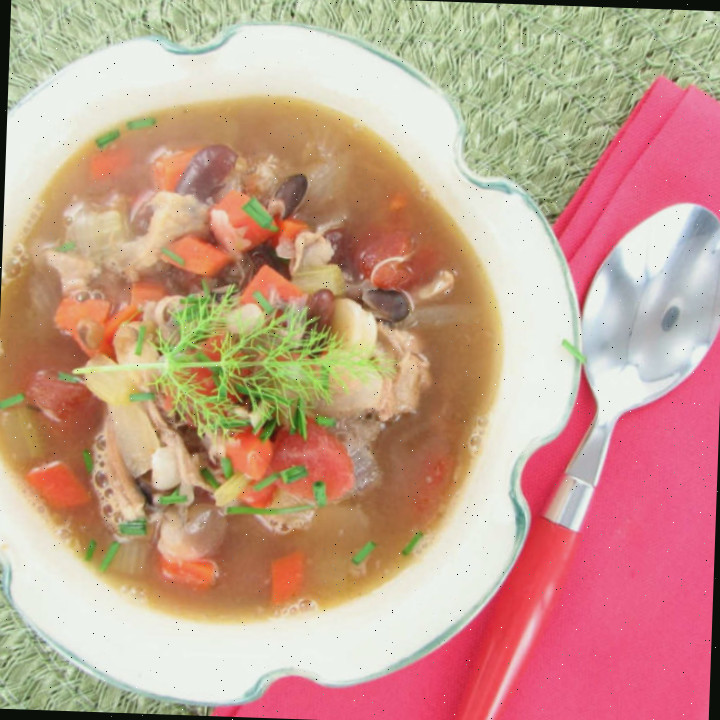 Sopa de Taco de Frango em uma tigela com um guardanapo rosa e colher.