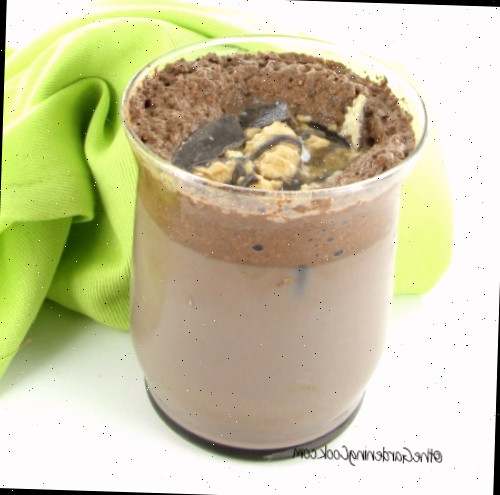 Leite com chocolate com sabor de café e cookies em um copo com um guardanapo verde.