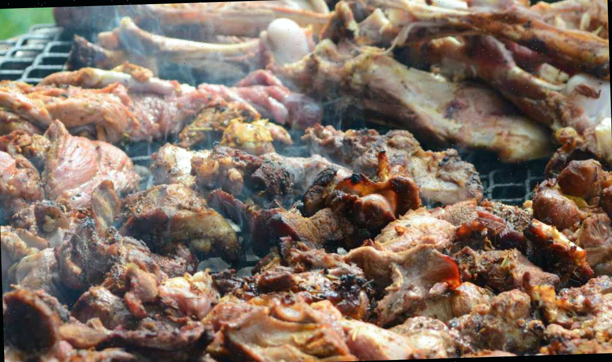 Uma grelha de churrasco com carne demais sobre ela.