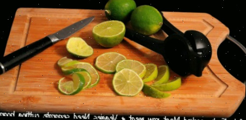Use tábuas de corte separadas Limões em uma tábua de corte com as palavras - Segurança em primeiro lugar: carne cozida, carne crua e legumes precisam de tábuas separadas.