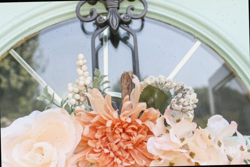 close up de flores e caule da abóbora no topo da guirlanda