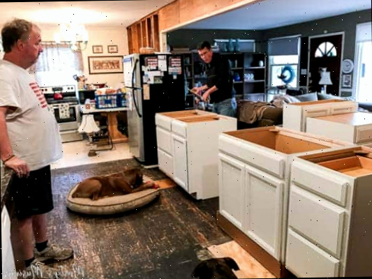 Um homem em pé na cozinha preparando comida
